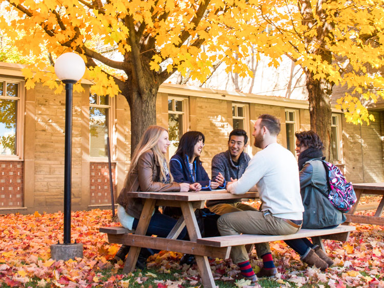 A small group of adults having a retreat in a courtyard during fall.