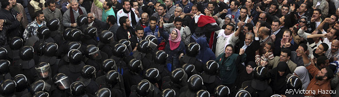 Egyptian protesters face anti-riot policemen in Cairo, Egypt, Friday, Jan. 28, 2011