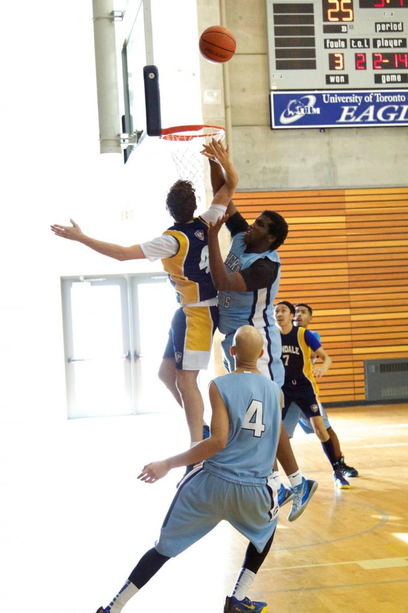 five basketball players vying for control of the ball