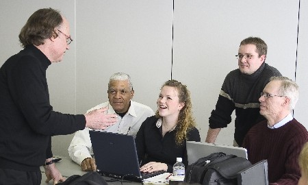 A professor teaching while four students look at him