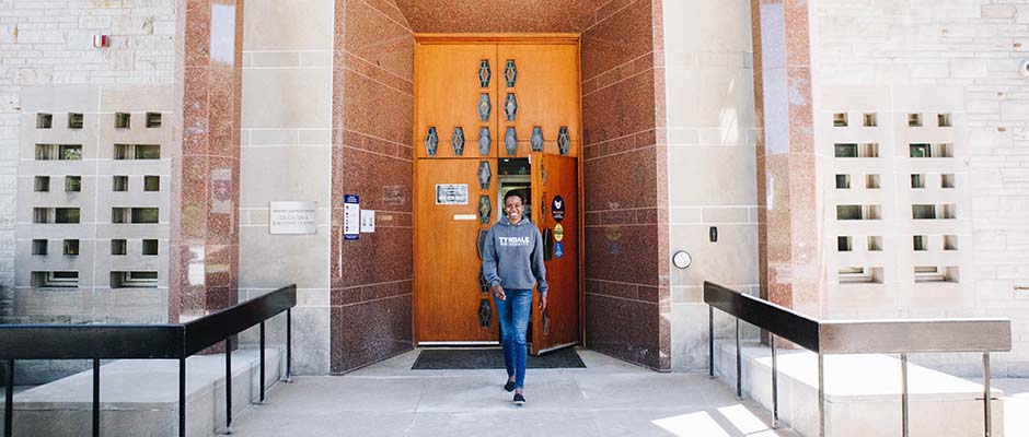 Female studentn walking out the Tyndale Universityfront doors