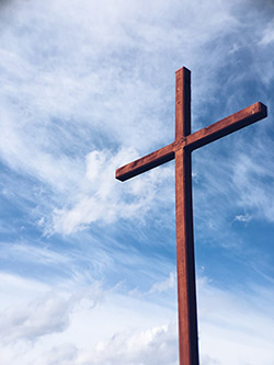 The Cross set against a blue cloud swirled sky