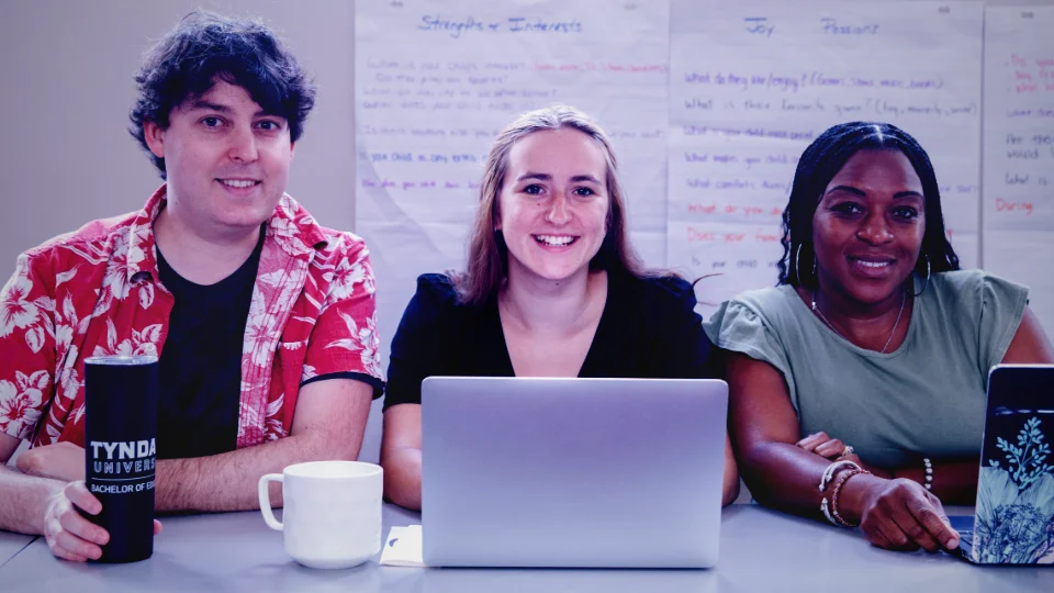 A group of three teacher candidates working at a table