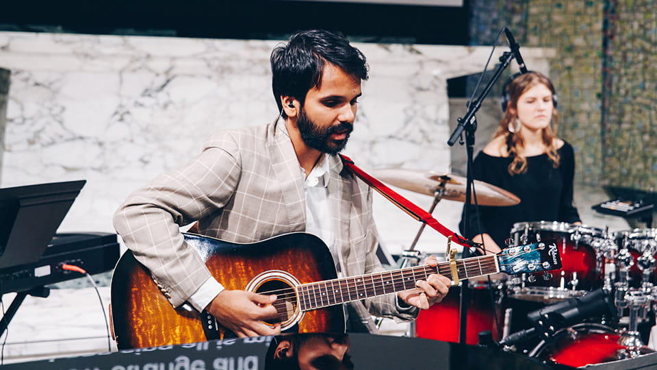 Student playing guitar in a band