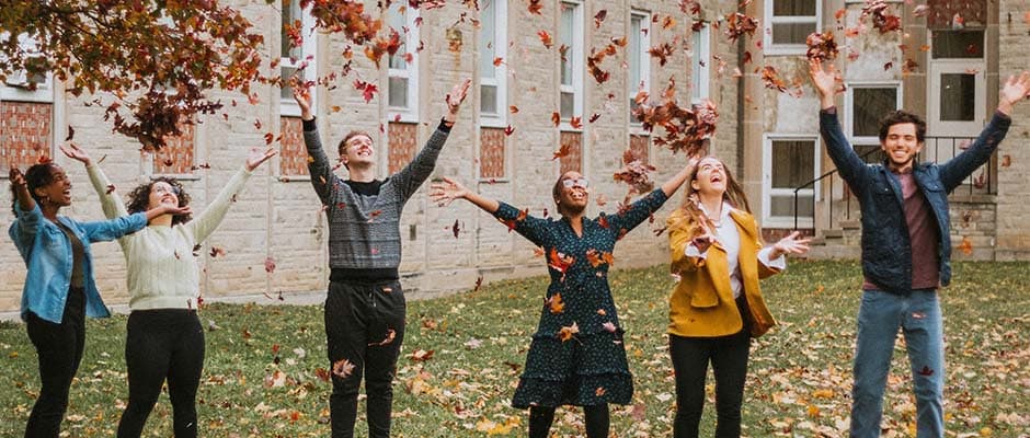 group of students catching falling autumn leaves