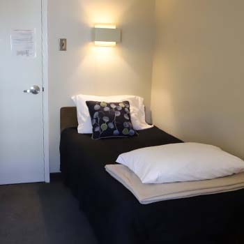 Room with a single bed near the main door entrance