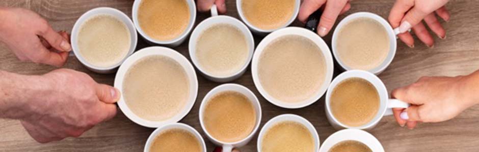 A group of hands holding cups of coffee