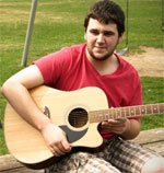 a male Tyndale student playing guitar