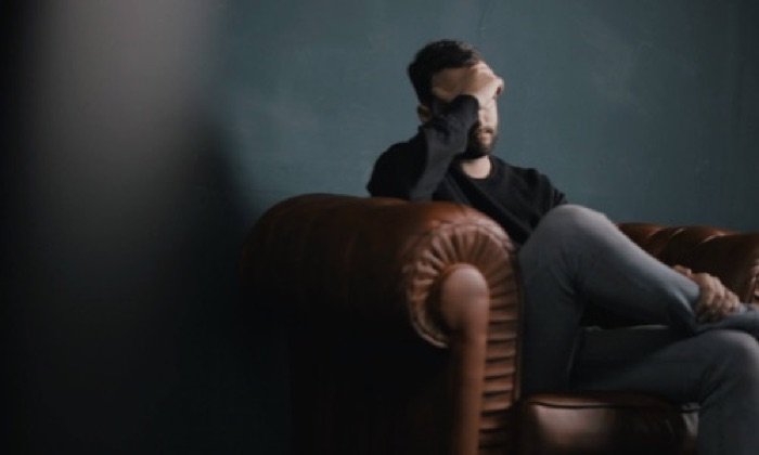 Discouraged male sitting on a couch