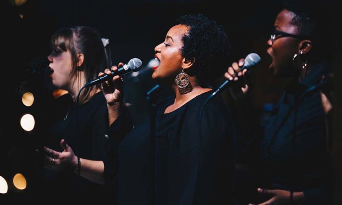 3 people singing into microphone