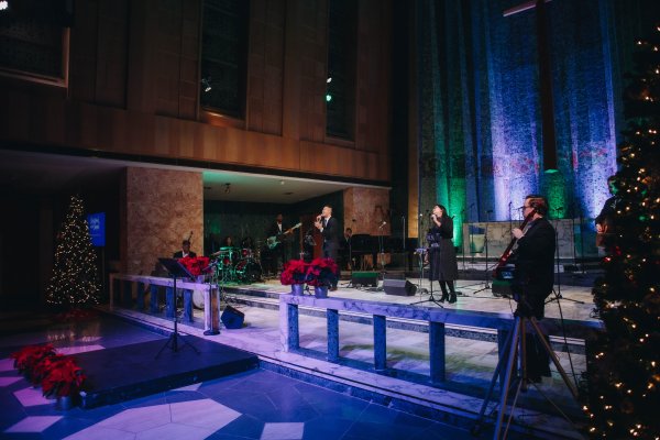 A wide view of the Worship Project singing and playing instruments on stage