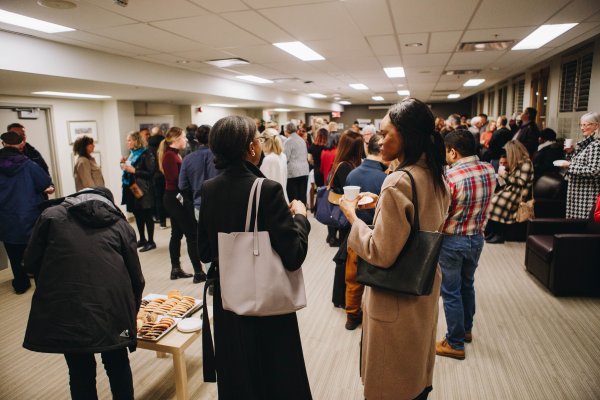 Attendees socializing with beverages and snacks in the Tyndale Commons