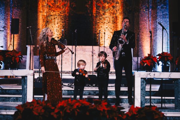 A family of four playing the violin and saxaphone together