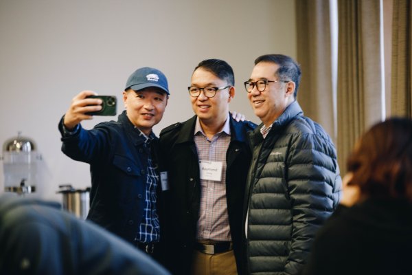A group of three men taking a phone camera selfie picture