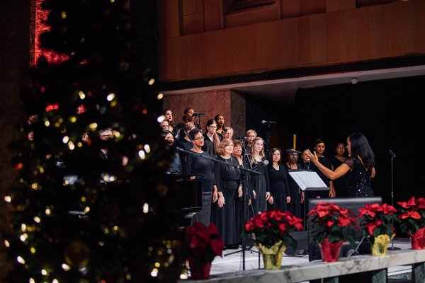 Members of the Tyndale Community Choir singing amidst the Christmas Tree