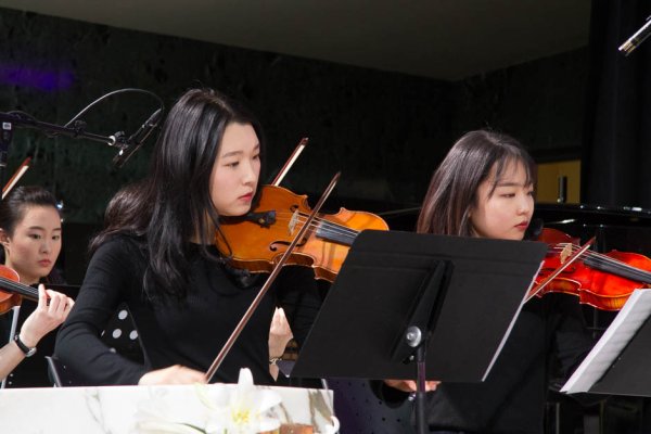 The orchestra with two women playing violin