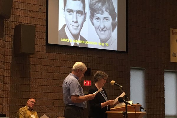 Two LCBM alumni speaking at podium