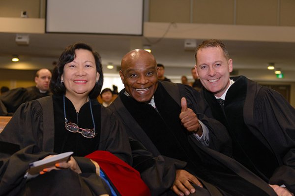 Three graduates posing and smiling