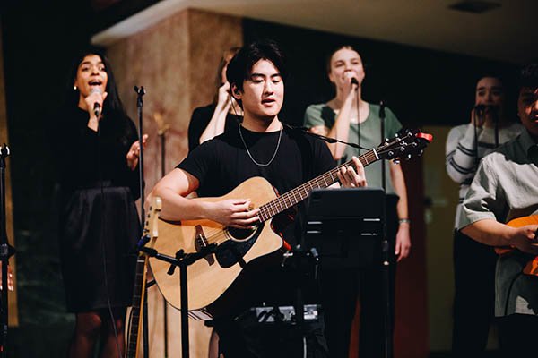 Tyndale student playing guitar on stage