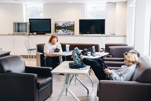 Two guys sitting in the mens lounge