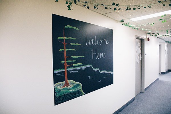 Hallway with a chalkboard saying "Welcome Home"
