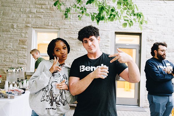 Two students gesturing with the peace symbol