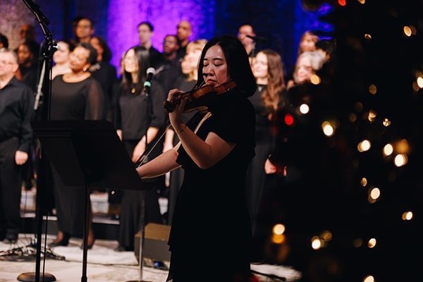 Violinist playing with choir in the background