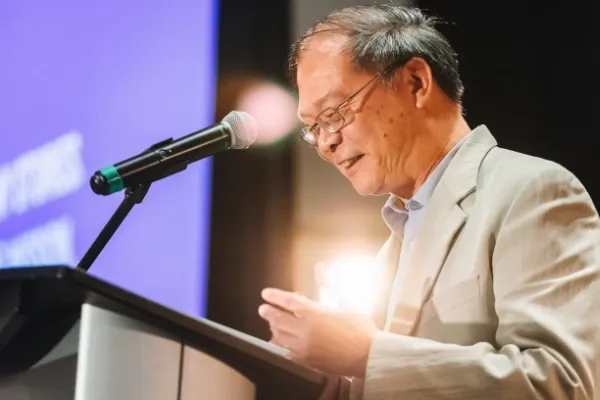 Rev. CY Yan speaking at podium