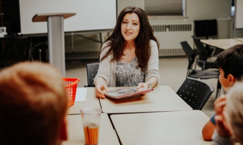 Teacher at table with students